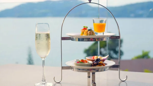 香槟酒杯 盛满了起泡的葡萄酒和开胃菜 背景是大海 奢华的酒会或典雅的夏季庆典 — 图库照片