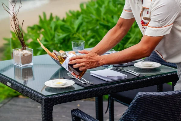 웨이터는 바닷가 식당에서 식탁을 낭만적 식사를 즐깁니다 바다의 파노라마같은 풍경을 — 스톡 사진