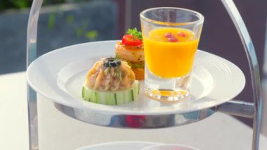 Lüks restoranda beyaz tabakta leziz mezeler. Açık hava restoranında kokteyl saati için atıştırmalıklar..
