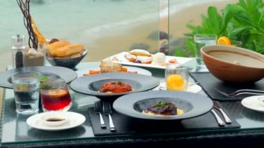 Phuket Adası 'ndaki lüks bir restoranda iki kişilik romantik deniz manzaralı bir akşam yemeği. Muhteşem deniz manzaralı bir masada servis edilen lezzetli yemekler romantik bir kutlama için mükemmel bir ortam..