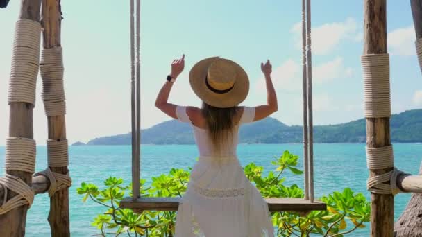 Mujer Joven Con Sombrero Paja Disfruta Vista Mar Desde Columpio — Vídeo de stock