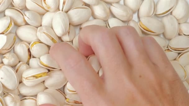 女の手はローストピスタチオナッツを取ります 栄養価の高い食事のための健康的でおいしいスナックオプション 食の概念と健康的な食事 — ストック動画