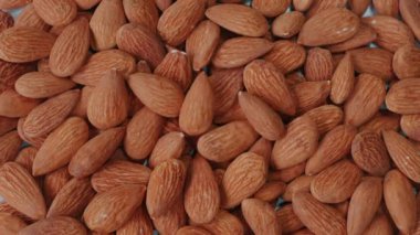 Masaya düşen organik, soyulmuş badem. Protein ve vitaminlerle paketlenmiş fındıklı, gevrek atıştırmalıklar. Sağlıklı yeme ve beslenme kavramı.