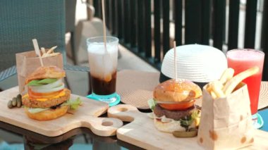 Klasik hamburgerler ve buzlu içecekler. Plaj tatil köyünde karpuz suyu ve buzlu latte. Manzaralı tüm zamanların favorilerinin tadını çıkarma kavramı.