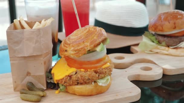 美味的汉堡包 上面有奶酪 培根和蔬菜 配以西瓜奶昔和冰拿铁 在海滨餐馆享用美味佳肴的概念 — 图库视频影像