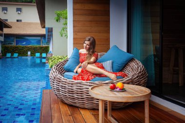 Yaşam tarzı konsepti. Güzel beyaz kadın tatil yerindeki havuzda tatilin tadını çıkarıyor..