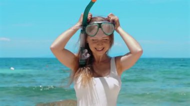 Mutlu kadın turist okyanusta şnorkelle yüzüyor, mayo giyiyor ve şnorkel maskesi takıyor. Tayland seyahati, yaz tatili. Sualtı keşfi ve plaj rahatlığı kavramı.