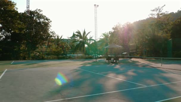 テニスコートネット 空っぽの遊び場 誰も見ていないフィールド 日没は美しい日没の熱帯の背景をもたらします 屋外スポーツとレジャーのコンセプト — ストック動画