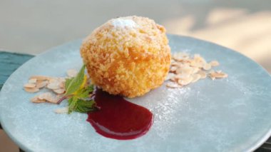 Çilek soslu ve badem fıstıklı vanilyalı dondurma. Geleneksel İtalyan tatlısı, lezzetli ve çıtır çıtır. Tatil sırasında gurme ziyafeti kavramı.