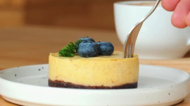Erkek El Taze Limonlu Cheesecake Dilimini Aldı. Lezzetli limonlu cheesecake diliminin elle kaldırılması. Krem peynirli, yaban mersinli ve çatallı gurme tatlısı..