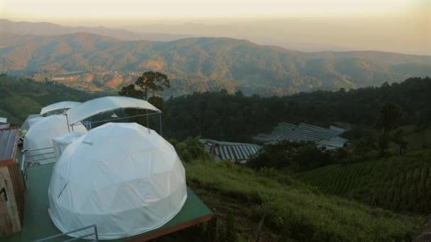 静谧的野营帐篷 栖息在茂密的草地上 群山映衬着炽热的落日的天空 泰国旅行 户外探险 — 图库视频影像