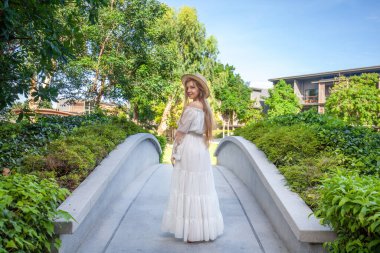 Serene gelin bereketli Tayland tatil beldesinde dolaşır, doğa güzelliğini kucaklar. Şık beyaz elbiseler içinde düğün mutluluğu.