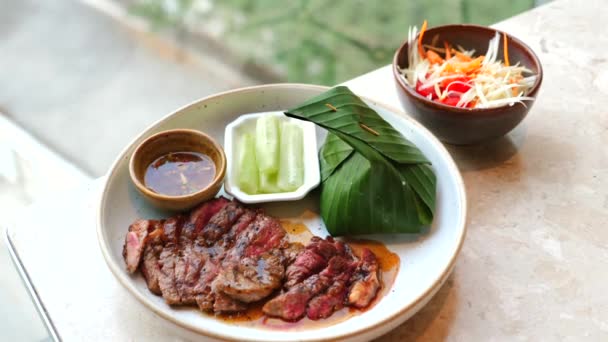 Ribeye Steak与Gourmet Flair 多汁的里贝牛排 精练的烤着 用黑胡椒装饰 由泰国香蕉叶米和木瓜沙拉配搭而成的餐馆 — 图库视频影像
