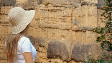 Kadın uçurumun kenarında duruyor, aşağıdaki geniş kanyona ve sıradağlara bakıyor. Görkemli kumtaşı oluşumları ve yükselen uçurumlar, ilham verici manzaralar. Milli parkın doğal güzelliği