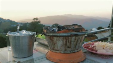Tayland barbekü ızgarası, gün batımı manzaralı sıcak tava. Güzel bir yemek, kamp tatilinde harika bir açık hava..