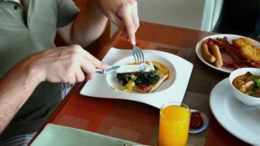Erkek, ıspanak ve yumurtalarla besleyici kahvaltıdan zevk alır, sağlıklı yeme alışkanlıklarını teşvik eder..