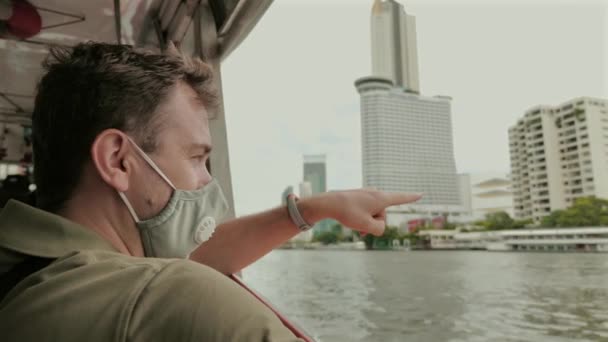 Άντρας Μάσκα Που Δείχνει Τον Ορίζοντα Της Πόλης Από Σκάφος — Αρχείο Βίντεο