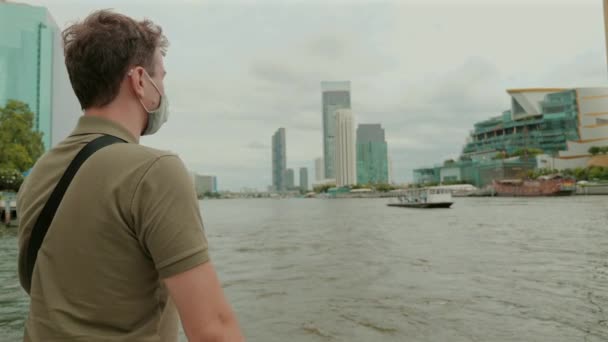 Man Met Masker Tijdens Het Verkennen Van Stedelijke Riverfront Landschap — Stockvideo