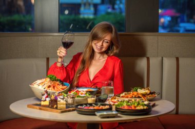 Zarif bir kadın kaliteli bir restoranda şarapla gurme yemeğinin tadını çıkarıyor. Gastronomi ve yaşam tarzı.