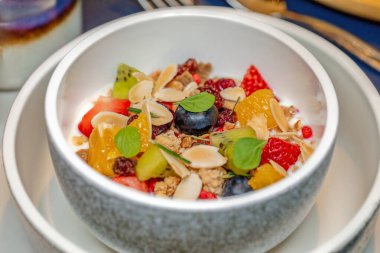 Taze meyve salatası ve granola kasede servis edilir. Sağlıklı yemek ve yaşam tarzı.