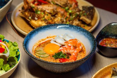 Baharatlı geleneksel Asya deniz ürünleri çorbası ve taze malzemeler. Gurme mutfağı..