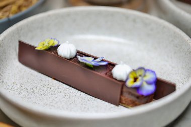 Gurme çikolatalı tatlı, yenilebilir çiçeklerle süslenmiş. Güzel yemekler ve pastaneler..