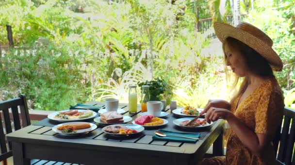 在阳光灿烂的日子里 优雅的女人享受着美味的户外早午餐 在乡村庭院里享用着各种健康的菜肴和新鲜的果汁 烹调和周末休闲 — 图库视频影像