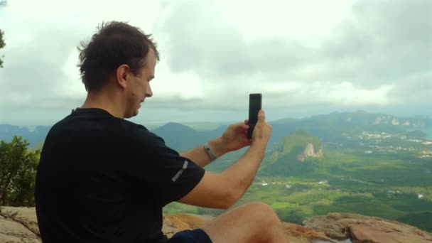 Manusia Menangkap Pemandangan Gunung Dengan Smartphone Duduk Puncak Berbatu Setelah — Stok Video