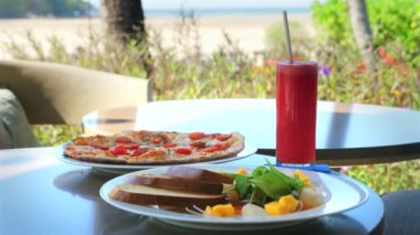 Taze karpuz içeceği ve deniz kenarındaki restoran masasında sağlıklı bir yemek. Yaz tatili ve açık hava yemeği..