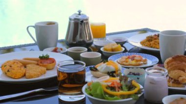 Otel kahvaltısı, deniz manzaralı balkonda sunulan çeşitli taze ve sağlıklı gıda seçenekleriyle servis ediliyor. Aşçılık turizmi ve yaşam tarzı.