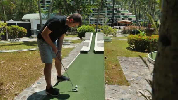 Seorang Pria Bermain Golf Mini Lapangan Hijau Selama Kegiatan Liburan — Stok Video