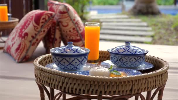 Tranquil Outdoor Breakfast Setup Traditional Ceramic Bowls Glass Orange Juice — Stock Video