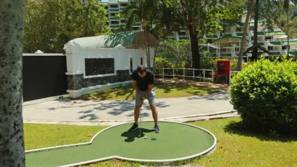 Homme Jouant Mini Golf Par Une Journée Ensoleillée Entourée Verdure — Video