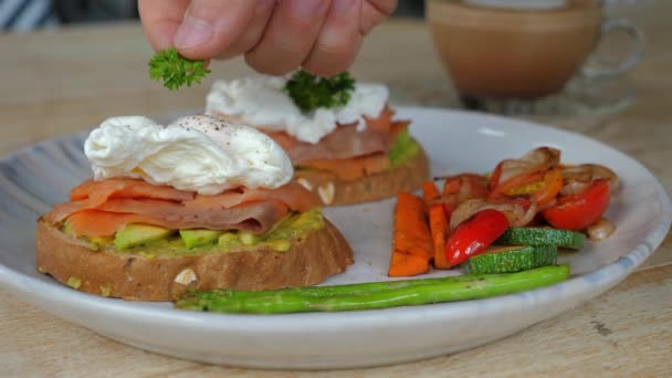 グリル野菜を添えたトーストには 密猟された卵 スモークサーモン アボカドが付いたグルメブレックファスト 栄養のある朝食 健康的な食べ物とライフスタイル — ストック動画