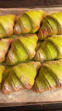 Tepside taze pişmiş kibrit kruvasanları, modern kıvrımlı sanatsal fırın ürünleri sergileniyor. Gurme hamur işleri ve aşçılık sanatları.