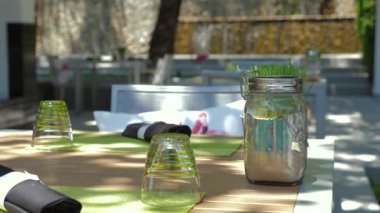 Yeşil cam süslemeli şık bir restoran masası ve sakin bahçe ortamında eşsiz bir süs eşyası. Alfresk yemek ve masa dekorasyonu.