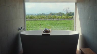 Geniş pencereden manzaralı lüks banyo küveti rahatlamayı, organik yaşam tarzını ve sağlığını destekliyor..