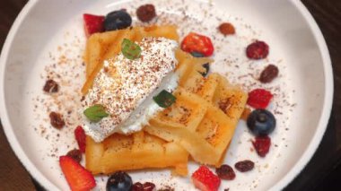 Krem şantili nefis ev yapımı waffle 'lar, taze böğürtlenler ve beyaz tabakta naneli yapraklar, nefis kahvaltı için hazır. Kahvaltı ve Tatlı İkram.