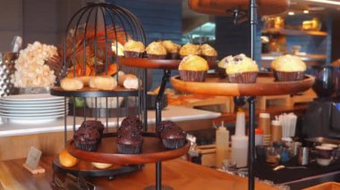 Konforlu kafe ya da fırın ortamındaki çok katmanlı vitrindeki lezzetli muffin ve hamur işleri, kahvaltı ya da tatlı ikram etmek için mükemmel. Yiyecek ve içecek..