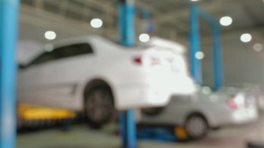 Araç tamir atölyesinin bulanık görüntüsü, hidrolik rampalarda kaldırılan araçlar, otomotiv bakımı ve onarımı.
