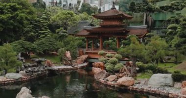 Geleneksel ahşap çadırı olan sakin Japon bahçesi yemyeşil ve kayalarla çevrili sakin gölet.