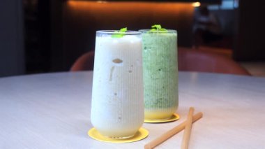 Sofrada zarif bardaklarda içecekler, iki bambu pipet, sağlıklı yaşam tarzı ve dengeli diyet..