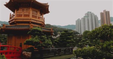 Kırmızı köprüsü ve arka planında gökdelenleri olan geleneksel Çin bahçesinde Pagoda