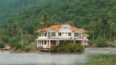 Bereketli yeşillik ve sakin doğal ortamda palmiye ağaçlarıyla çevrili tropikal bir ev..