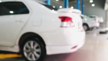 Parlak ışıklandırılmış arabaların bulanık görüntüsü, modern oto tamirhanesi, bakım hizmetleri ve araç bakımı. Otomatik Onarım ve Bakım.