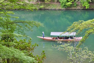 Nehir teknesinde insanlar eğleniyor. Arashiyama Kyoto Japonya