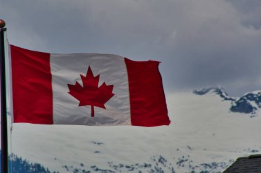 Karlı dağda dalgalanan Kanada bayrağının görüntüsü. MÖ. Squamish Kanada