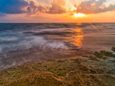 gün batımında kayalık sahil.