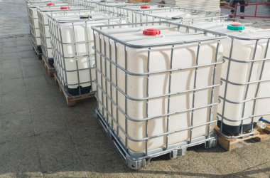Bir sürü küp su tankı. Dışarıya yığılmış 1000 litre konteynır.