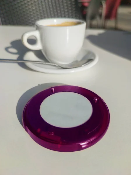 テラスでコーヒーカップに近いコースターページャーデバイス レストランの消費者のための無線通信装置 — ストック写真